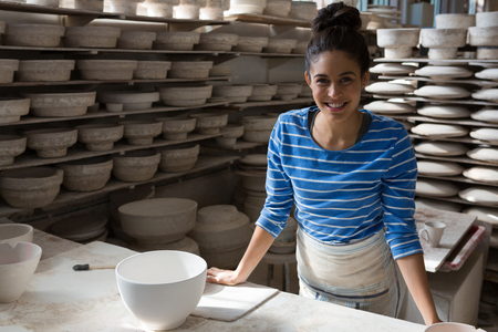 Portrait of female potter smiling in pottery workshopの写真素材