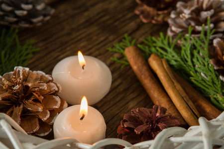 High agnle view of pine cones with illuminated candles and wreath on wooden tableの写真素材
