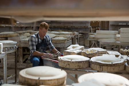 Male potter making a pot in pottery workshopの写真素材
