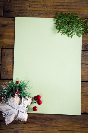 Close-up of christmas decoration with blank paper on wooden tableの写真素材