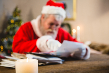 Santa Claus reading a letter at homeの写真素材