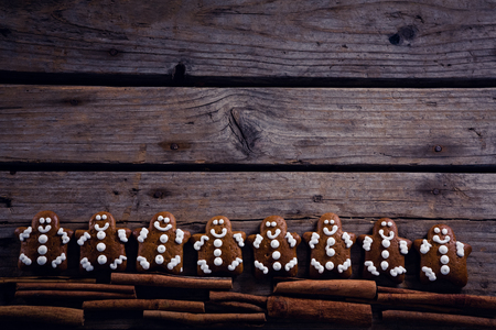 Overhead of gingerbread cookies and cinnamon sticks arranged on wooden plankの写真素材