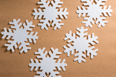 Overhead of white snowflakes on brown backgroundの写真素材
