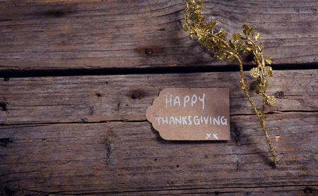 Overhead of thanksgiving card and flora on wooden plankの写真素材