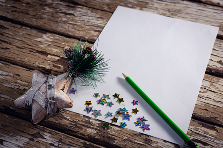 Close-up of christmas decoration, pen and blank paper on wooden plankの写真素材