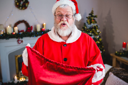 Portrait of santa claus holding gift sack at homeの写真素材