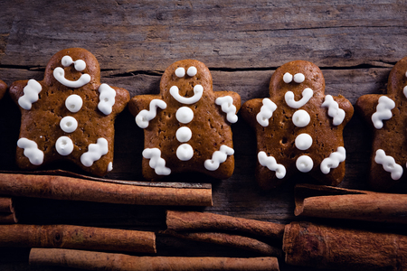 Close-up of gingerbread cookies and cinnamon sticks arranged on wooden plank