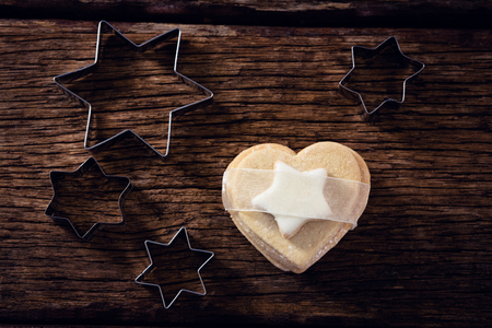 Overhead of cookie cutter and cookie on wooden plankの写真素材