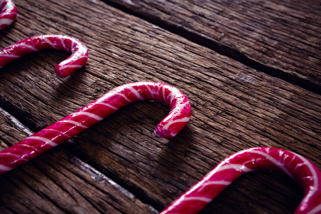 Close-up of pink candy canes arranged on wooden plankの写真素材
