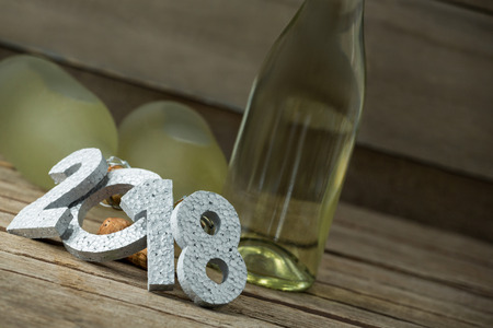 Close-up of New year number 2018 and champagne bottles arranged on wooden surface