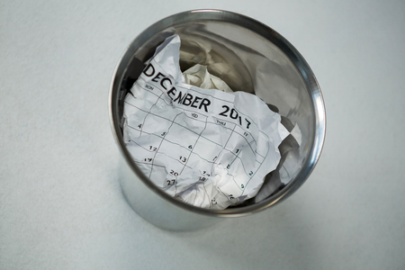 Close-up of crumpled calendar in dustbinの写真素材