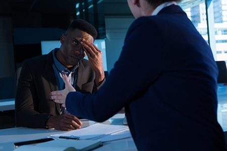 Businesswoman scolding her colleague at desk in officeの写真素材