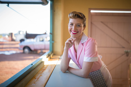 Young waitress standing at counter in restaurant