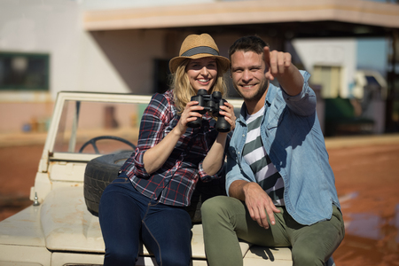 Happy couple sitting together on a carの写真素材
