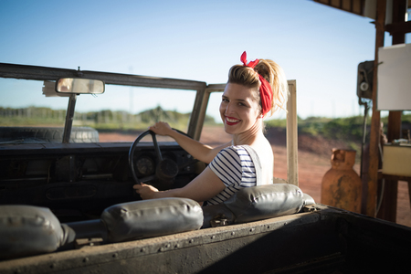 Beautiful woman sitting in car on a sunny dayの写真素材