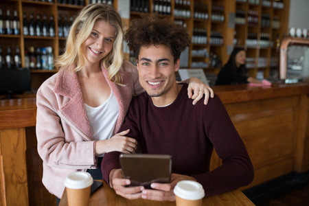 Portrait of happy couple using digital tablet in barの写真素材