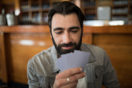Confident man playing cards in barの写真素材