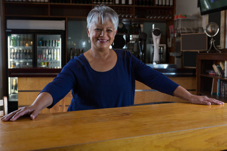 Portrait of waitress smiling near cafe counterの写真素材