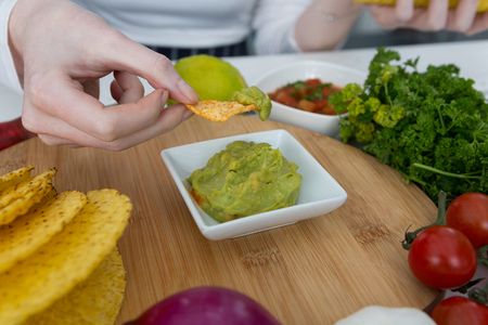 Mid-section of woman eating mexican foodの写真素材