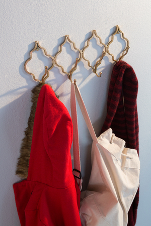 Close-up of warm clothes and bag hanging on hookの写真素材