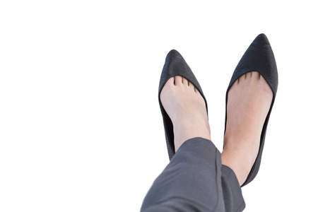 Female executives legs crossed at ankle against white backgroundの写真素材