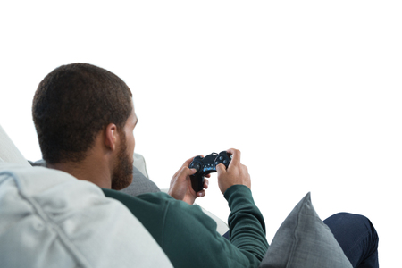 Rear view of man playing video game against white backgroundの写真素材