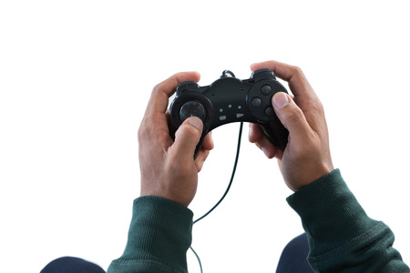 Hand of man playing video game against white background