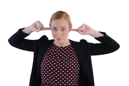 Annoyed woman covering her ears against white backgroundの写真素材