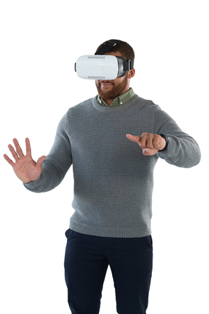 Male executive using virtual reality headset against white backgroundの写真素材