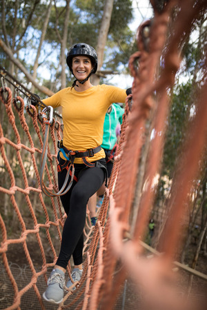 Happy woman walking on rope bridgeの写真素材