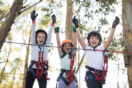 Portrait of happy kids cheering on bridgeの写真素材