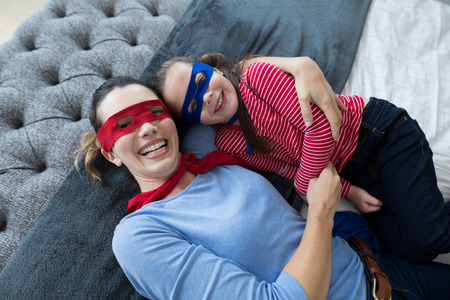 Overhead of mother and daughter lying on bedの写真素材