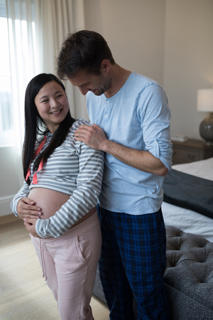 Happy man and woman interacting with each other in bedroomの写真素材