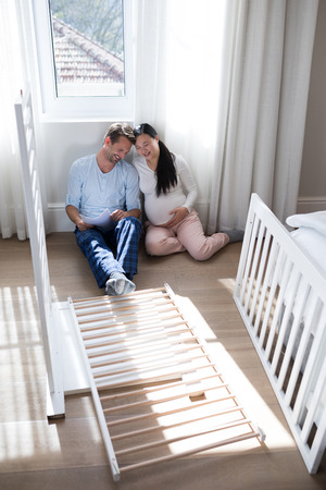 Affectionate couple sitting in bedroom at homeの写真素材