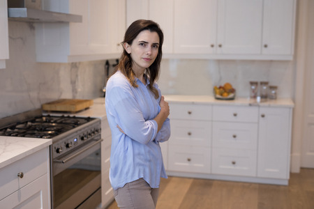 Beautiful woman standing in kitchen at homeの写真素材