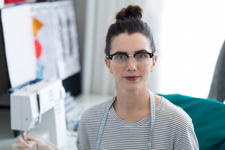 Fashion designer sitting on chair at homeの写真素材