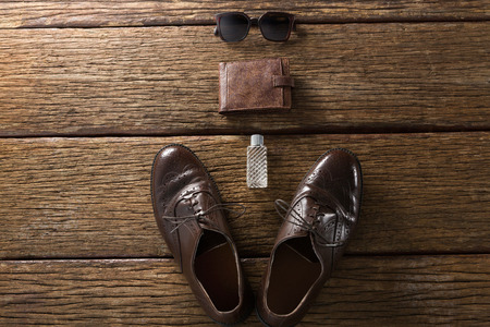 Shoes, perfume, wallet and sunglasses arranged on wooden plankの写真素材