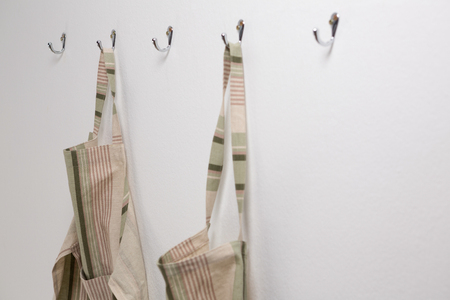 Close-up of aprons hanging on hookの写真素材