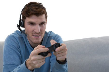 Young man playing video game against white background