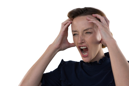 Frustrated female executive standing against white background
