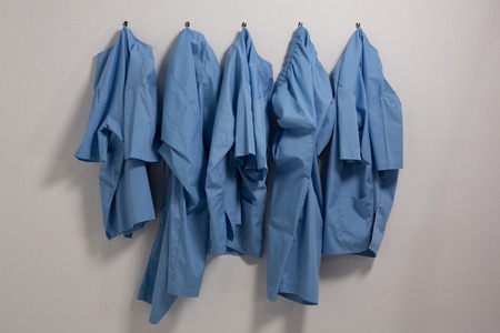 Scrubs hanging on hook against wallの写真素材