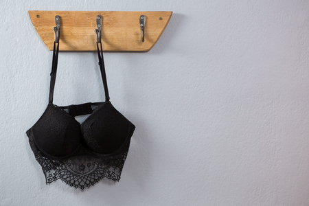 Lingerie hanging on hook against wallの写真素材