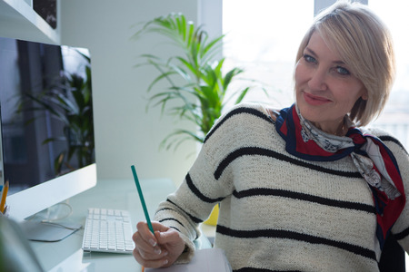 Portrait of confident woman sitting at tableの写真素材