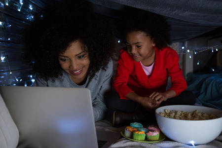 Mother and daughter using laptop at homeの写真素材