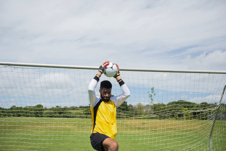 Goalkeeper ready to throw soccer ball in the groundの写真素材