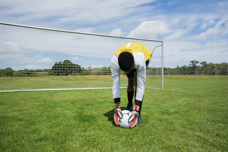 Goalkeeper ready to kick the soccer ball in the groundの写真素材