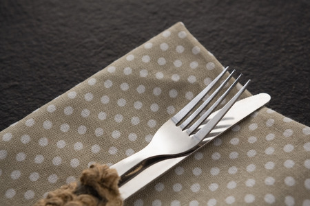 Close-up of fork and knife on a dotted napkinの写真素材