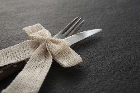 Close-up of fork and knife tied with a ribbonの写真素材