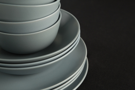 Close-up of dining plates set on black theme tableの写真素材