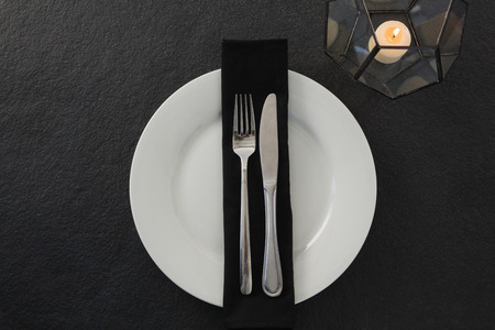 Close-up of table setting with lit candleの写真素材